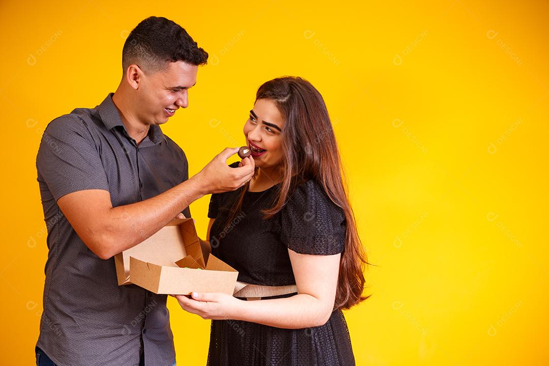 Casal de namorados com caixa de doces fazendo surpresa