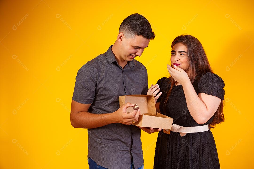 Casal de namorados com caixa de doces fazendo surpresa