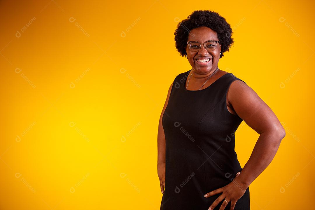 Mulher meia idade negra sorrindo olhando para a câmera