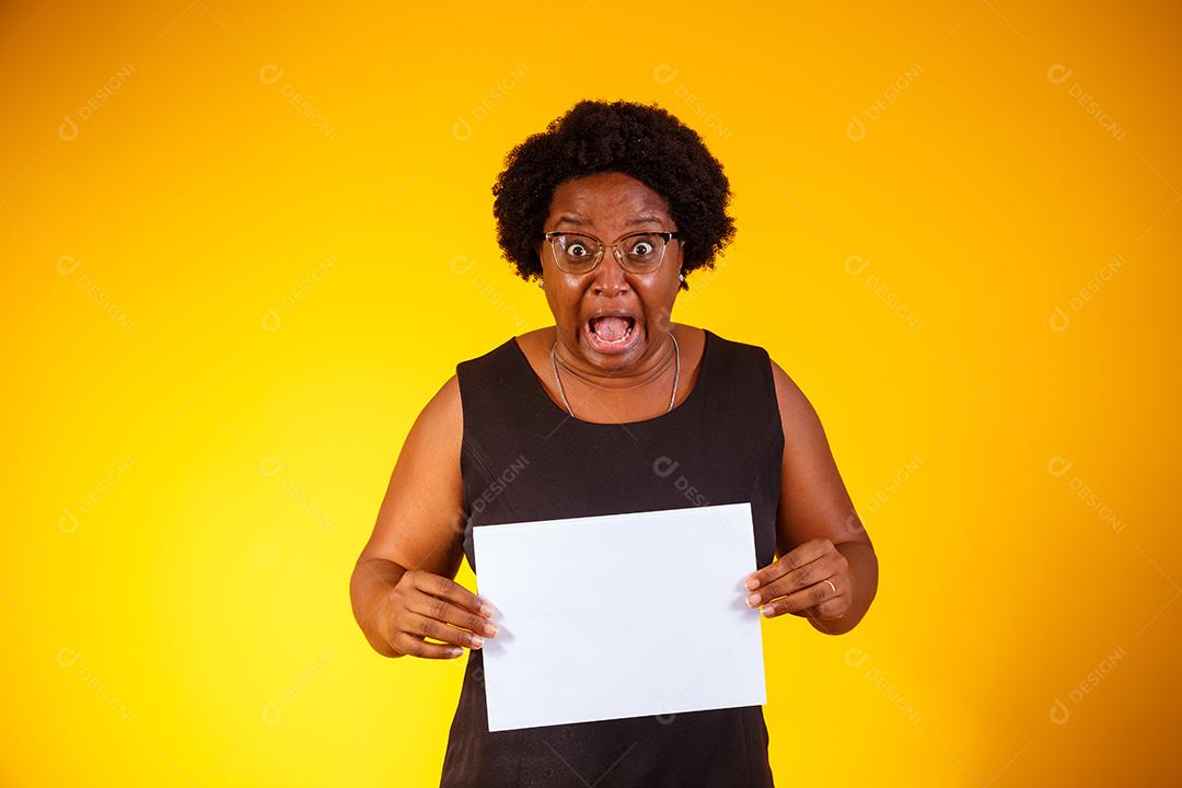 Mulher negra meia idade com expressão facial segurando folha branca