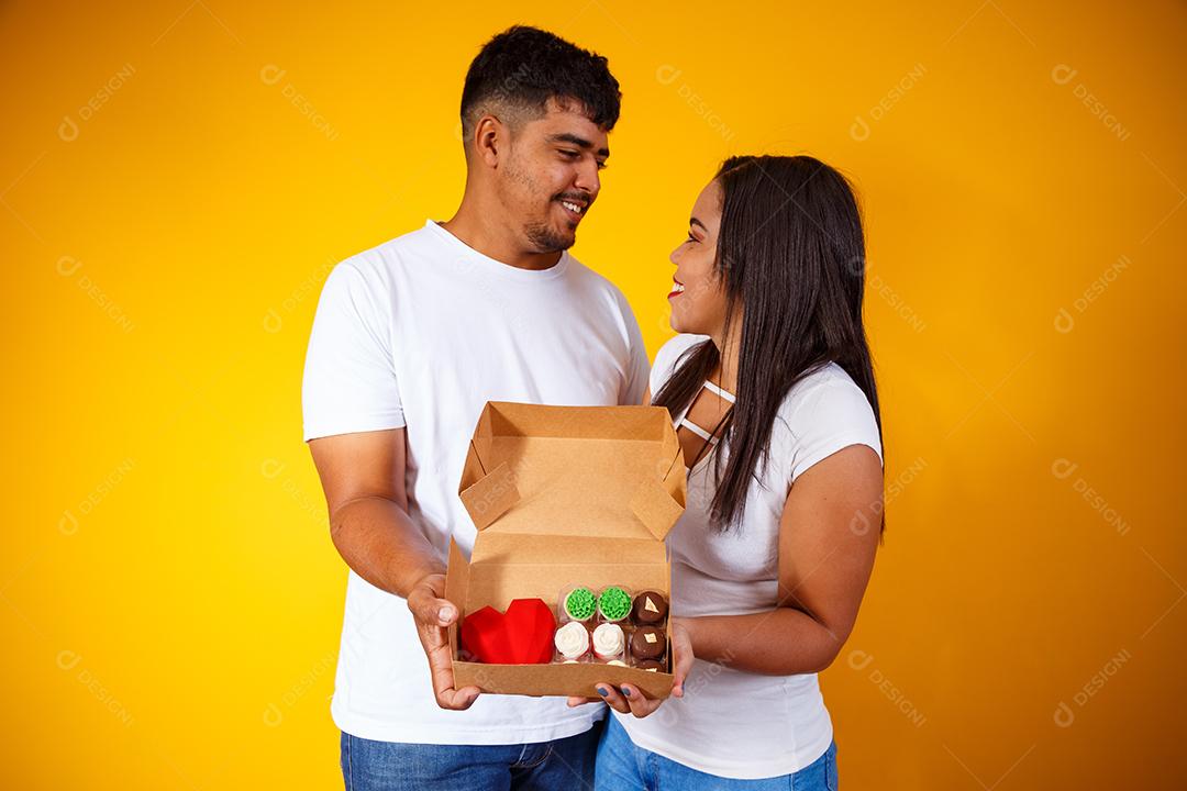 Casal de namorados com caixa de doces fazendo surpresa