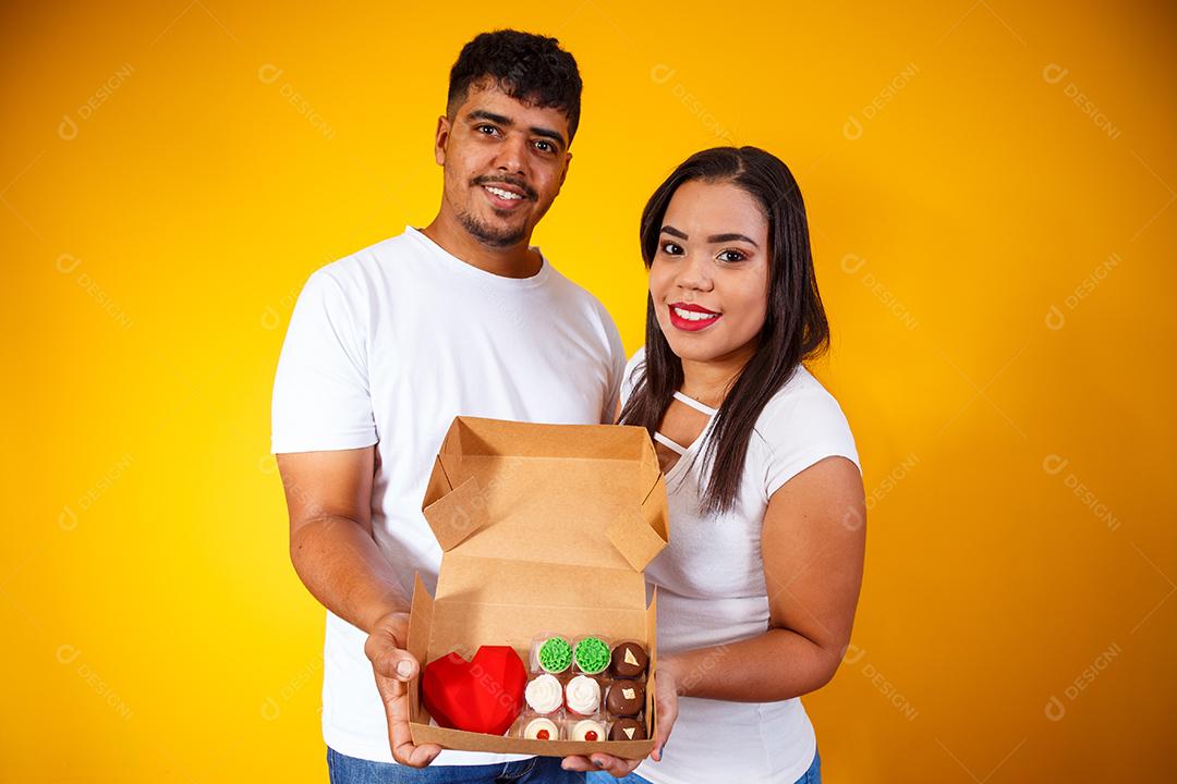 Casal de namorados com caixa de doces fazendo surpresa