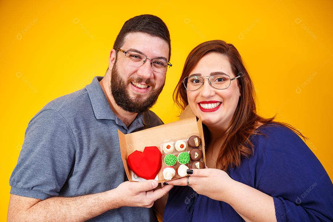 Casal de namorados com caixa de doces fazendo surpresa