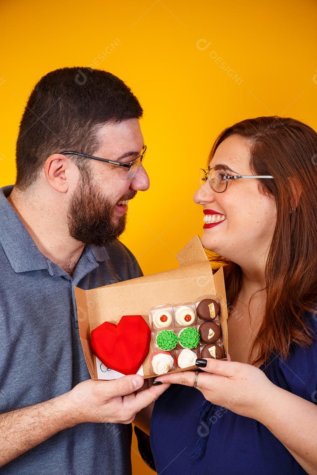 Casal de namorados com caixa de doces fazendo surpresa