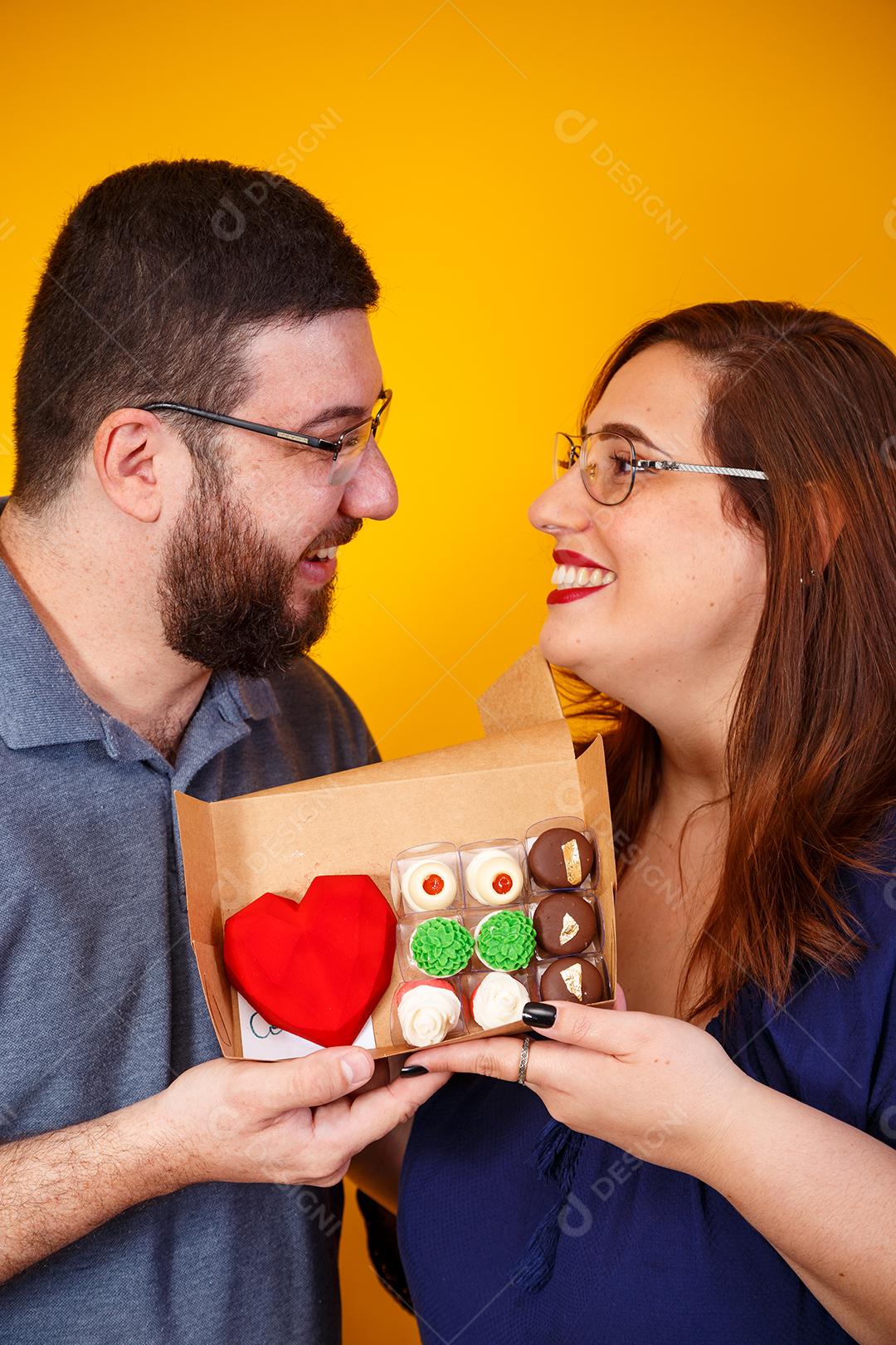 Casal de namorados com caixa de doces fazendo surpresa