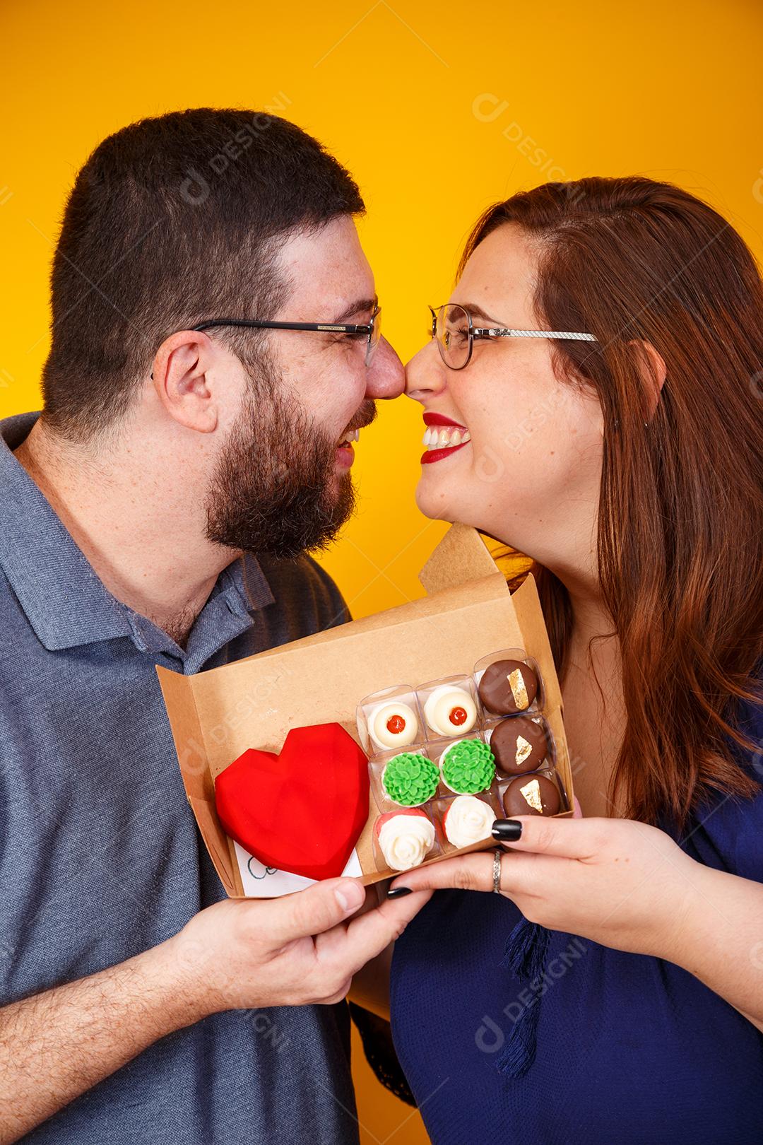 Casal de namorados com caixa de doces fazendo surpresa