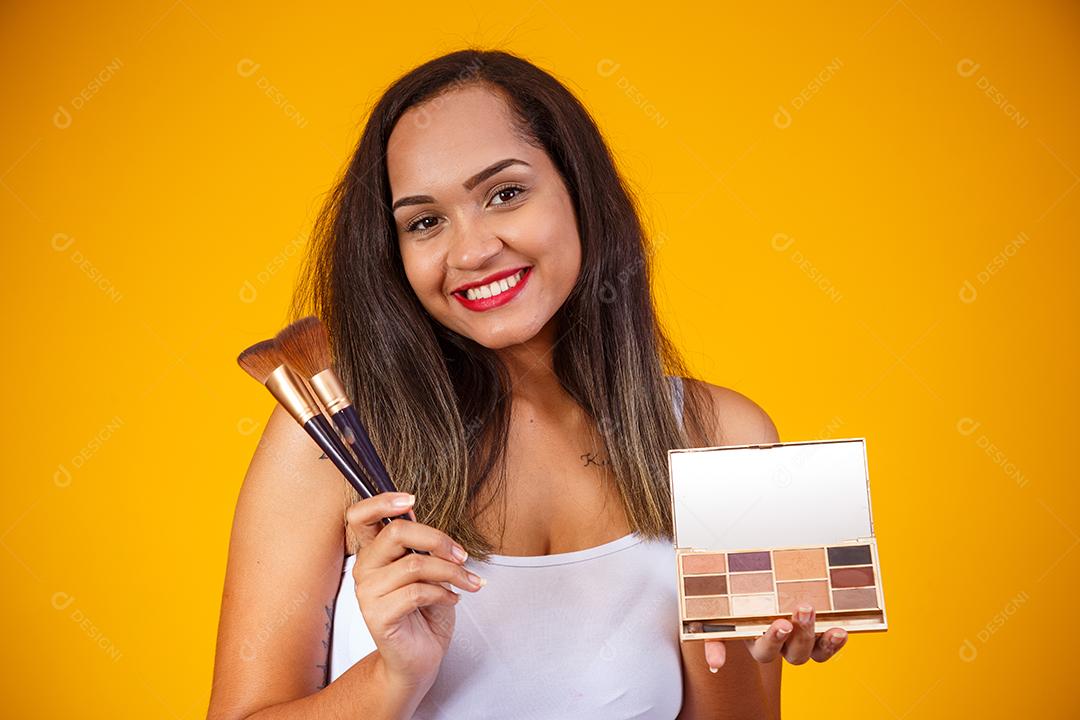 Bela Mulher Maquiadora profissional com Maquiagens e Pincéis na Mão