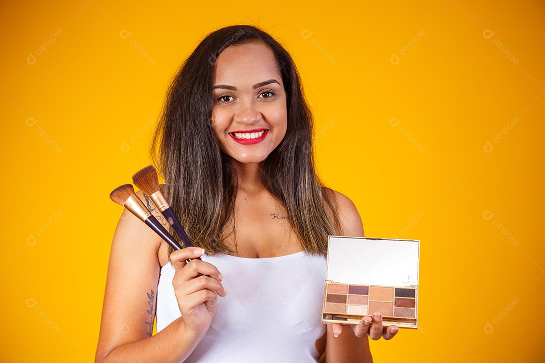 Bela Mulher Maquiadora profissional com Maquiagens e Pincéis na Mão