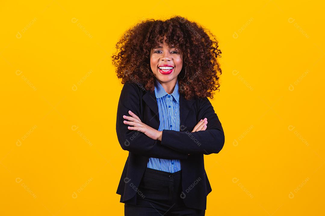 Mulher de cabelo cacheado com blazer preto em fundo amarelo