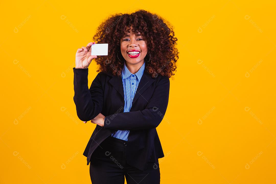 Mulher de cabelo cacheado com blazer preto em fundo amarelo