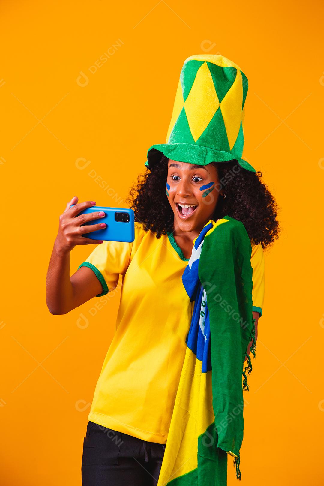 Fã brasileiro assistindo futebol no celular