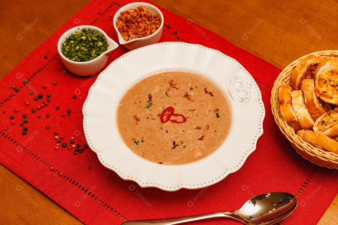 Delicioso caldo de feijão, Sopa de feijão, com fundo de madeira, fundo de tecido vermelho, com torradas, salsa