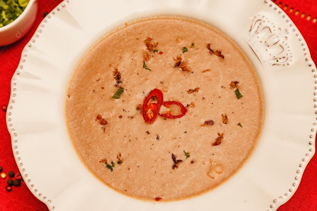 Delicioso caldo de feijão, Sopa de feijão, com fundo de madeira, fundo de tecido vermelho, com torradas, salsa