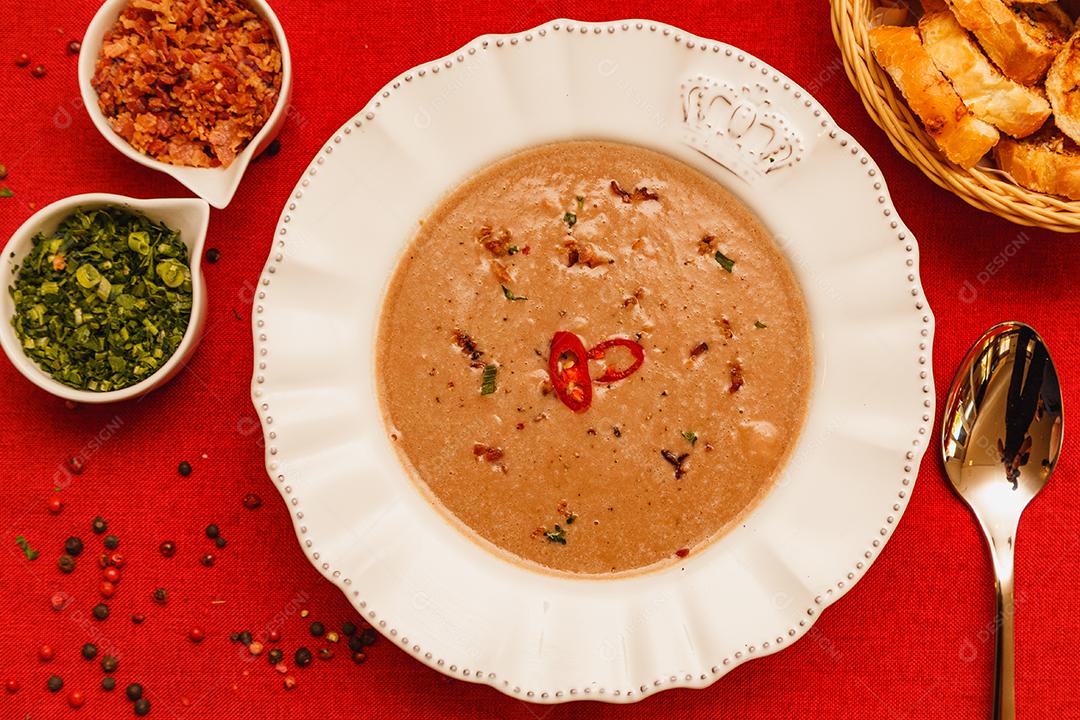 Delicioso caldo de feijão, Sopa de feijão, com fundo de madeira, fundo de tecido vermelho, com torradas, salsa