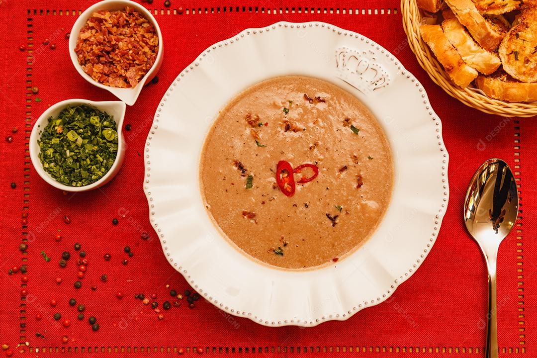 Delicioso caldo de feijão, Sopa de feijão, com fundo de madeira, fundo de tecido vermelho, com torradas, salsa