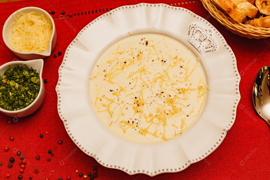 Delicioso e saboroso Caldo de Mandioca, caldo de batata, caldo com queijo ralado por cima e salsa