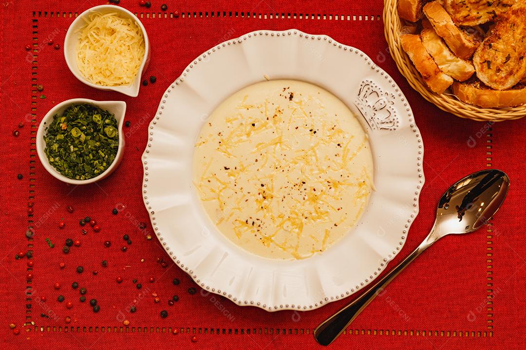 Delicioso e saboroso Caldo de Mandioca, caldo de batata, caldo com queijo ralado por cima e salsa