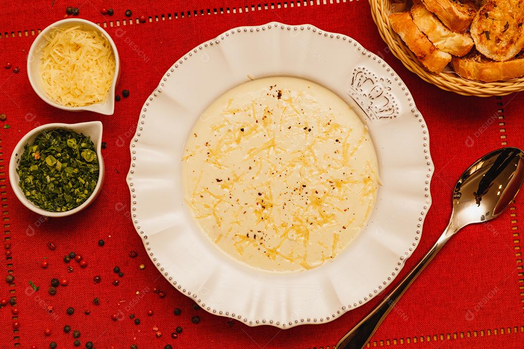Delicioso e saboroso Caldo de Mandioca, caldo de batata, caldo com queijo ralado por cima e salsa