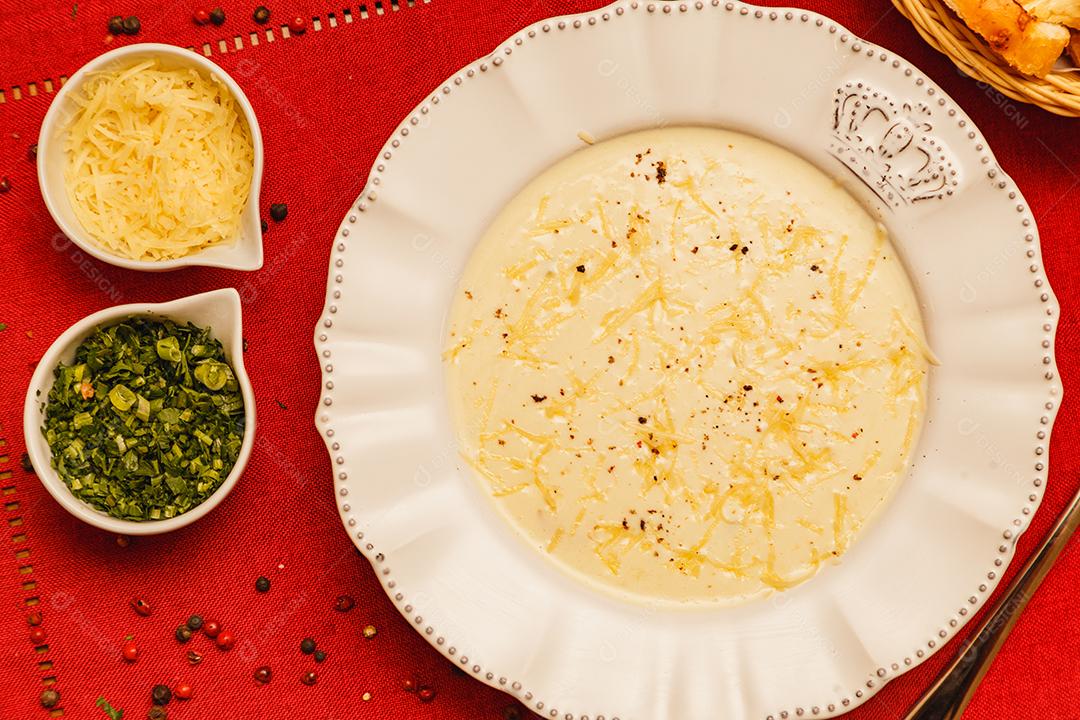 Delicioso e saboroso Caldo de Mandioca, caldo de batata, caldo com queijo ralado por cima e salsa