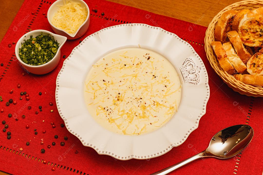 Delicioso e saboroso Caldo de Mandioca, caldo de batata, caldo com queijo ralado por cima e salsa