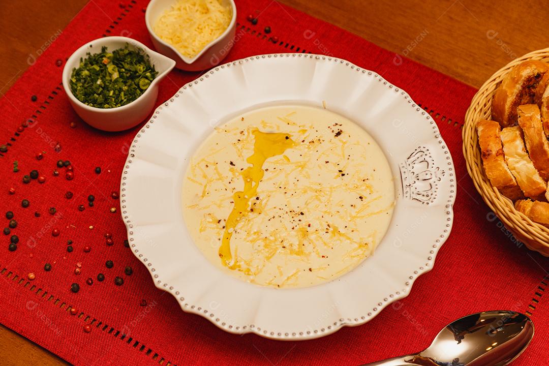 Delicioso e saboroso Caldo de Mandioca, caldo de batata, caldo com queijo ralado por cima e salsa