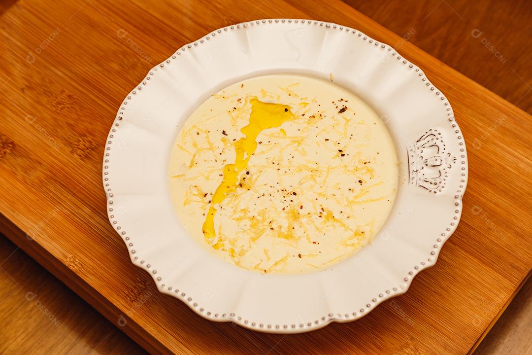 Delicioso e saboroso Caldo de Mandioca, caldo de batata, caldo com queijo ralado por cima e salsa