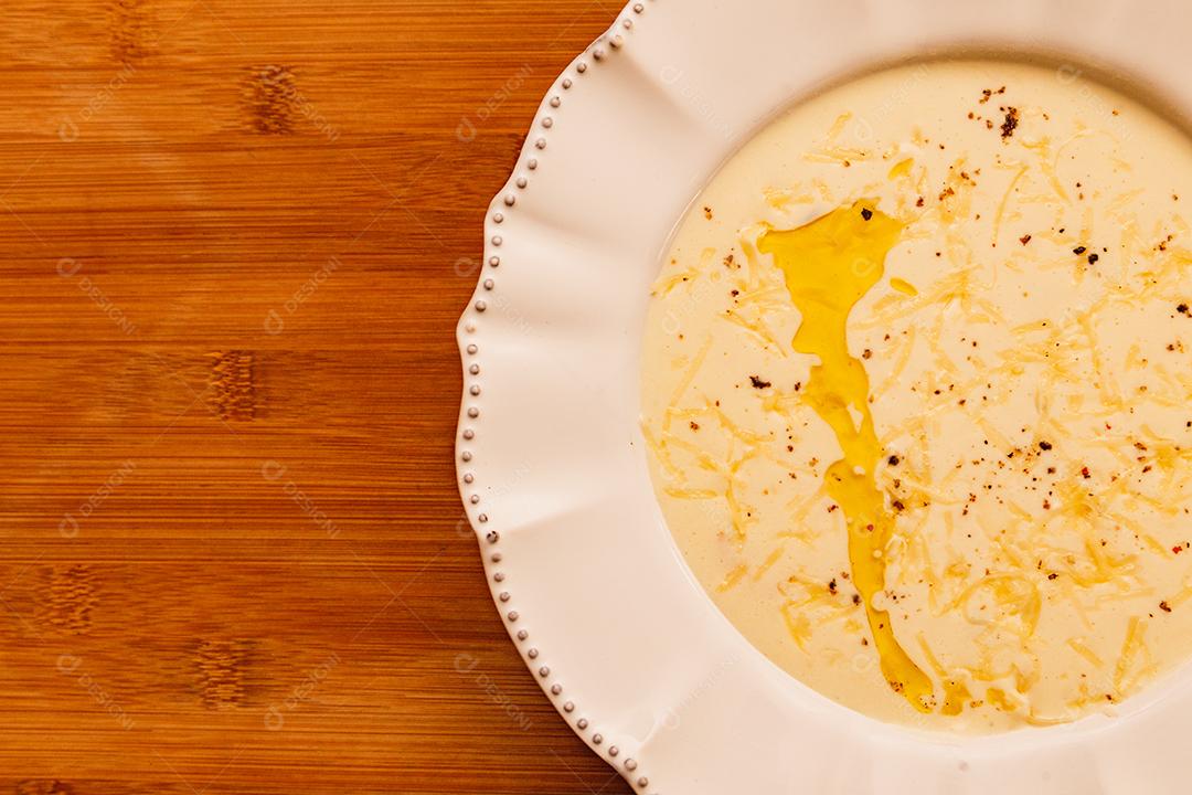 Delicioso e saboroso Caldo de Mandioca, caldo de batata, caldo com queijo ralado por cima e salsa