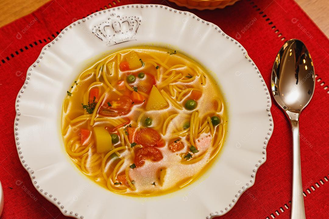 Deliciosa sopa de macarrão com legumes, sopa de macarrão com legumes, em um fundo de madeira