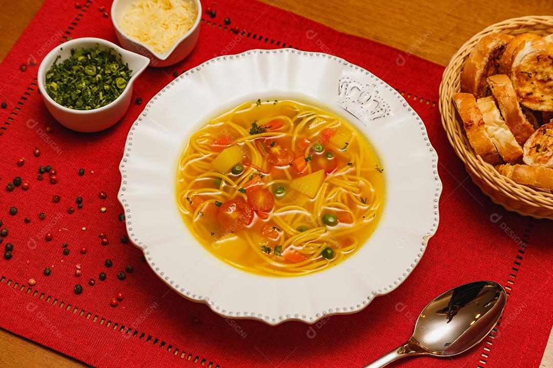 Deliciosa sopa de macarrão com legumes, sopa de macarrão com legumes, em um fundo de madeira