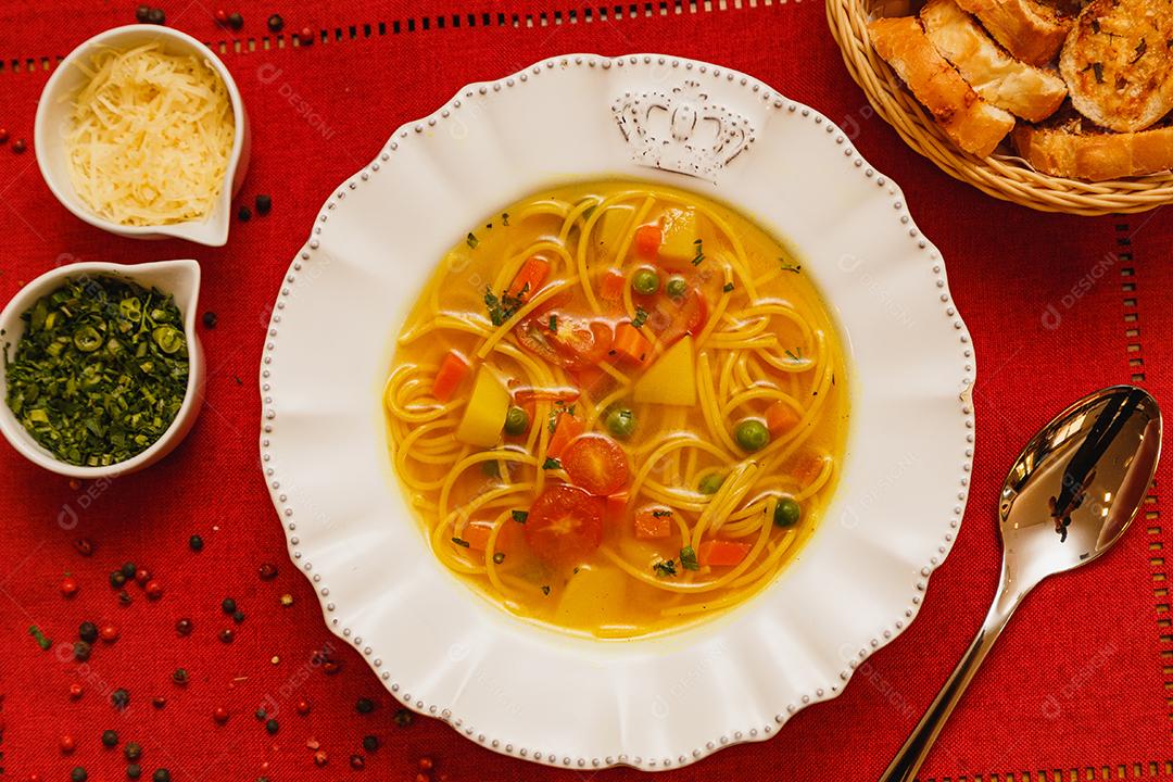 Deliciosa sopa de macarrão com legumes, sopa de macarrão com legumes, em um fundo de madeira