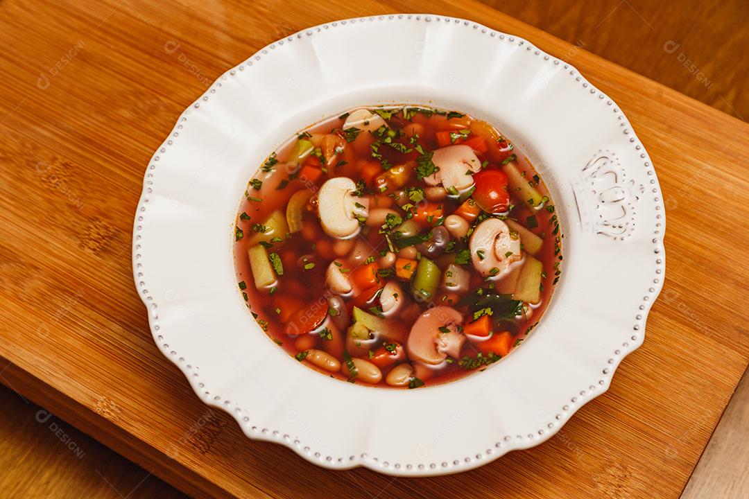 Delicioso caldo de cogumelos em molho de vinho, sopa de cogumelos em molho de vinho, com fundo de madeira