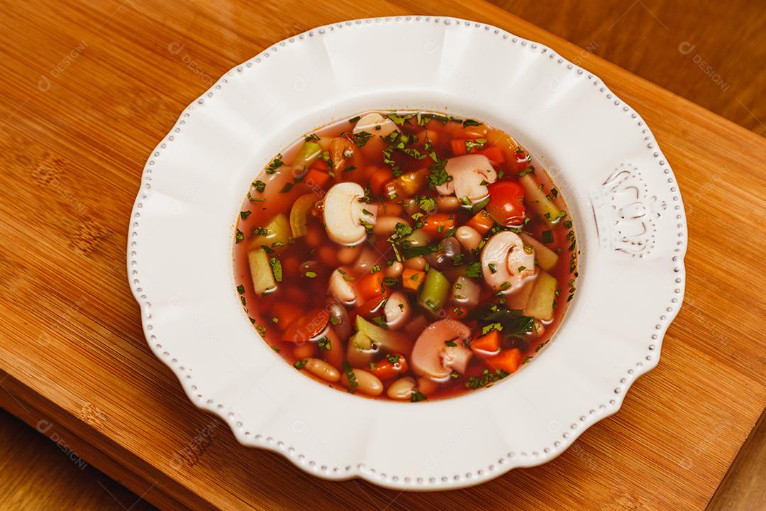 Delicioso caldo de cogumelos em molho de vinho, sopa de cogumelos em molho de vinho, com fundo de madeira