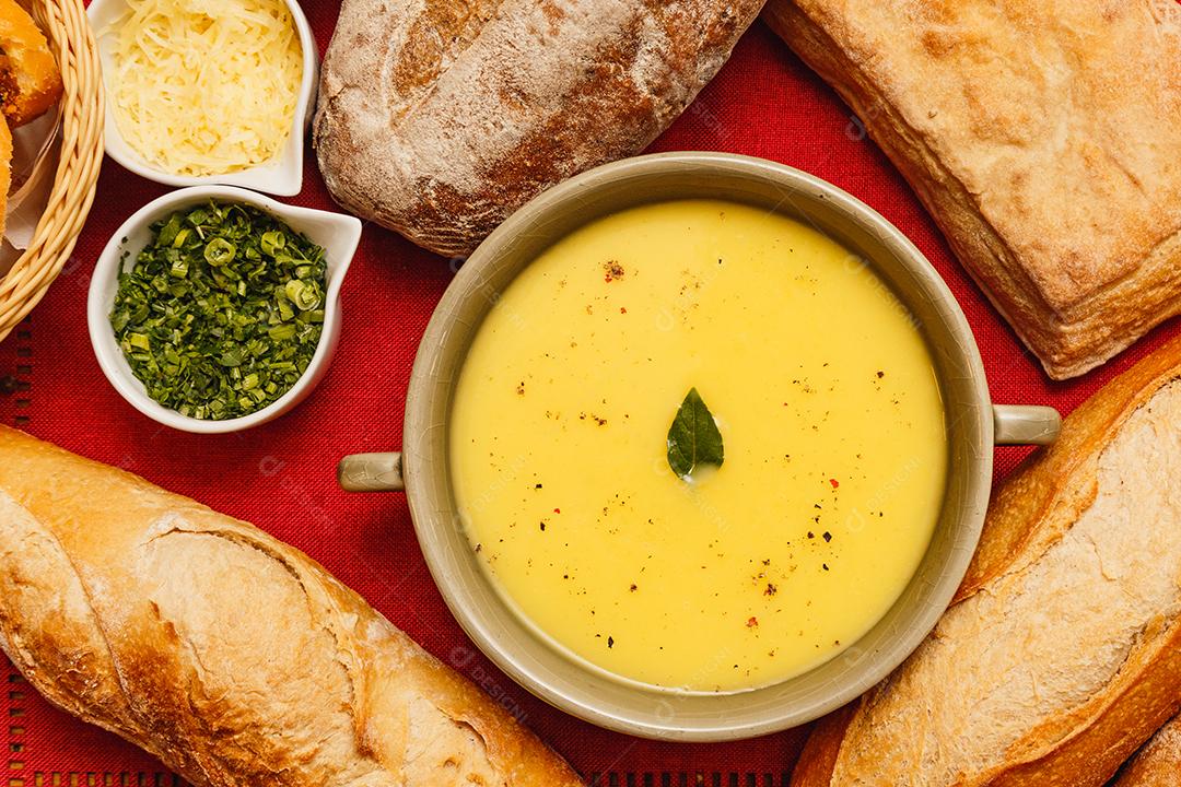 Delicioso caldo de batata ou mandioca, sopa de batata ou mandioca, vegetariano, salsa, com fundo de madeira e tecido vermelho