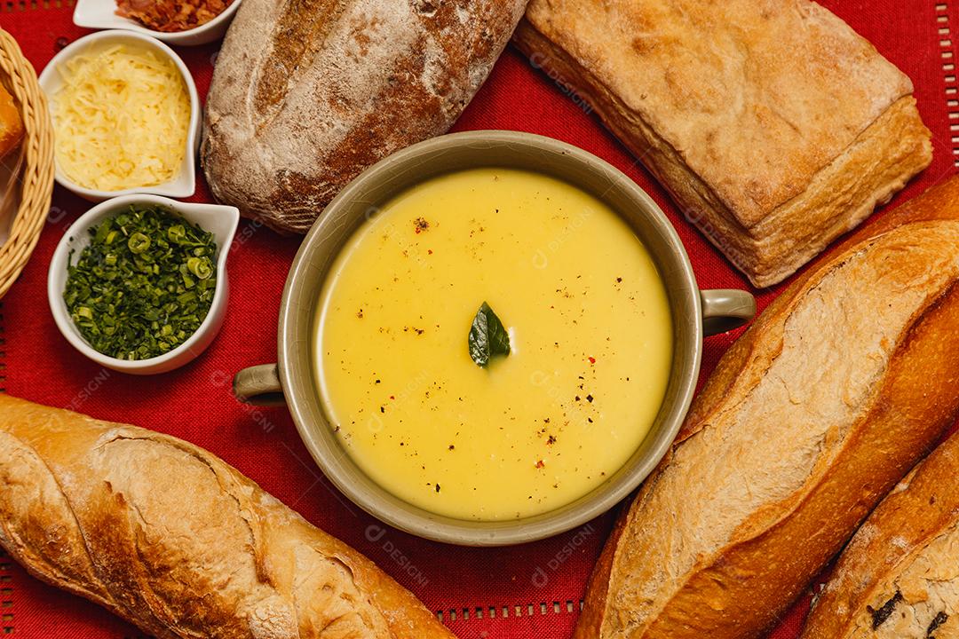 Delicioso caldo de batata ou mandioca, sopa de batata ou mandioca, vegetariano, salsa, com fundo de madeira e tecido vermelho