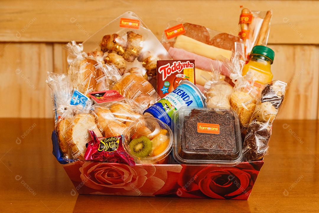 Cesta basica de comida sobre uma mesa de madeira