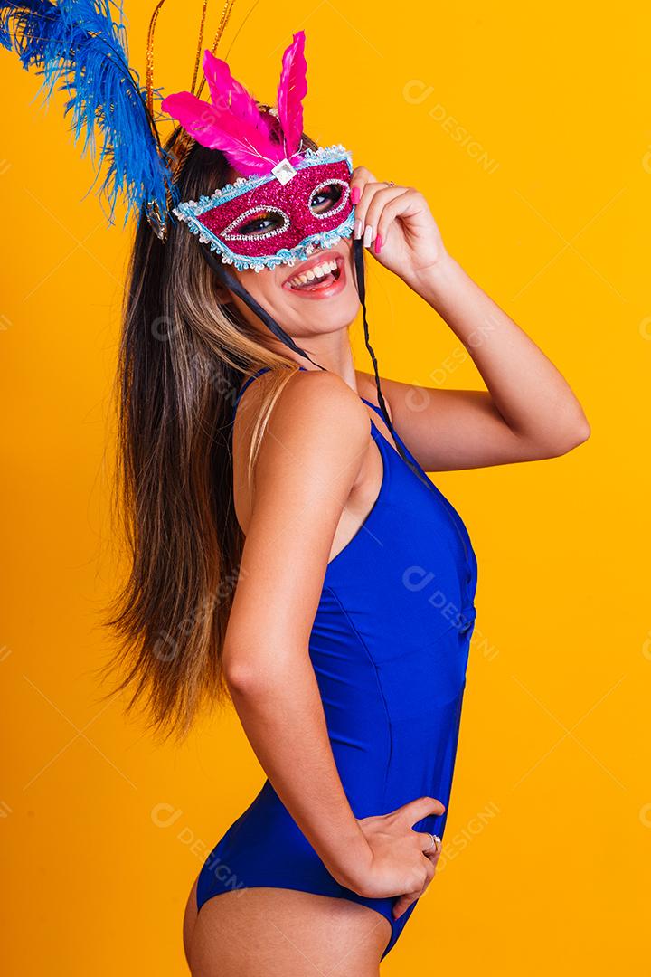 Mulher bonita vestida para a noite de carnaval. Mulher sorridente pronta para curtir o carnaval com máscara