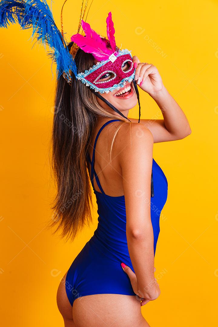 Mulher bonita vestida para a noite de carnaval. Mulher sorridente pronta para curtir o carnaval com máscara