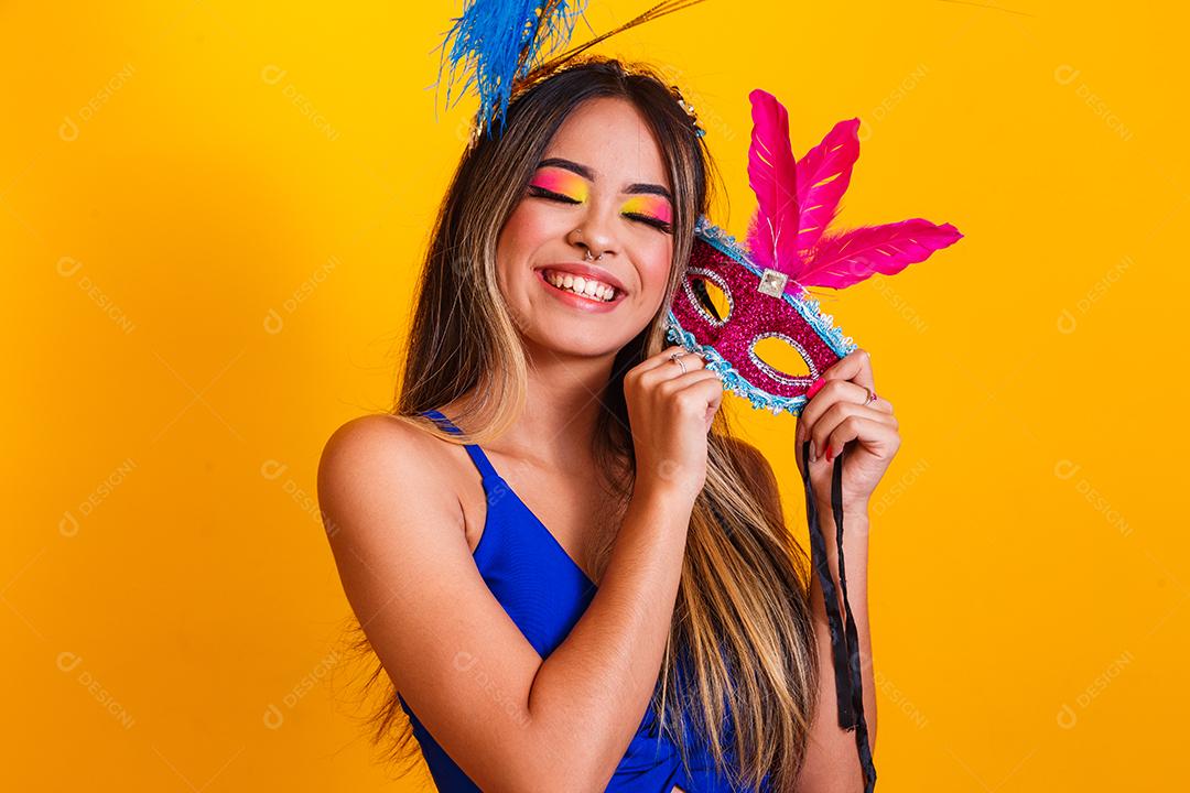 Mulher bonita vestida para a noite de carnaval. Mulher sorridente pronta para curtir o carnaval com máscara