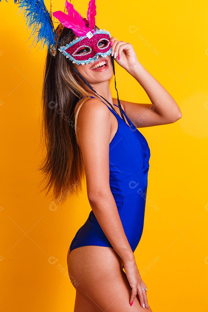 Mulher bonita vestida para a noite de carnaval. Mulher sorridente pronta para curtir o carnaval com máscara