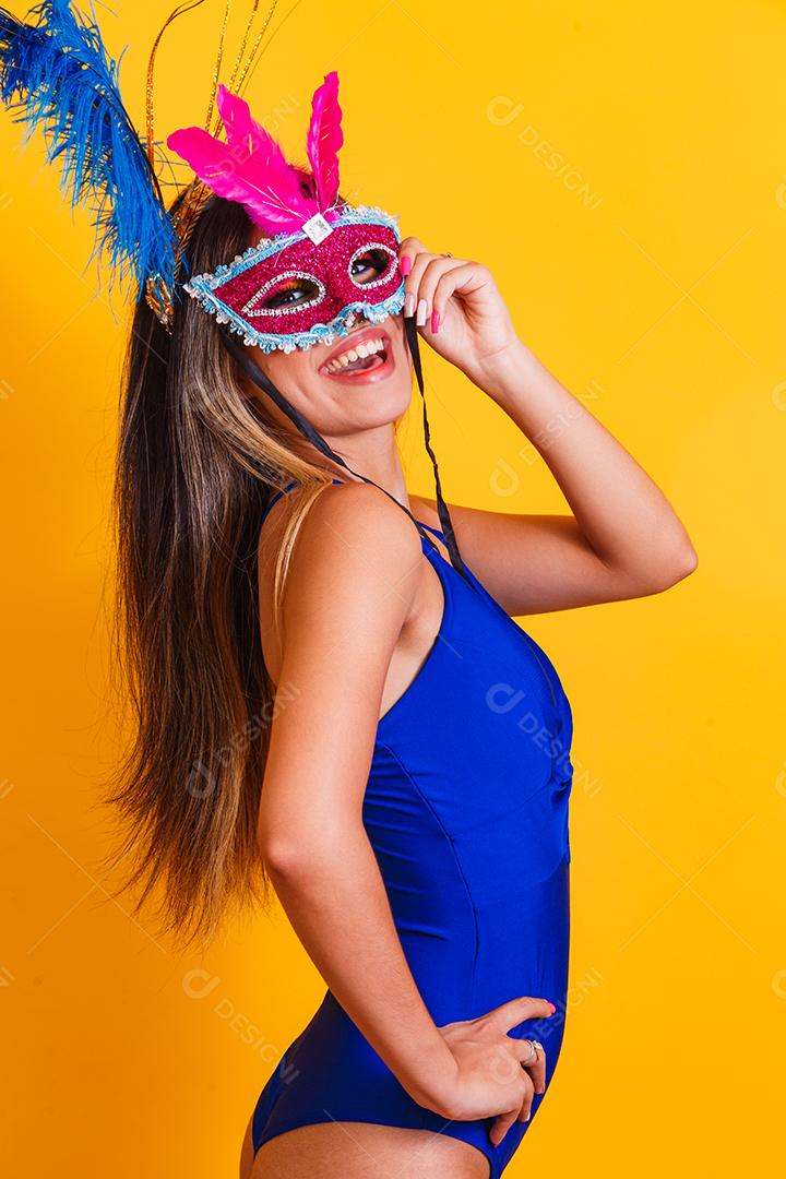 Mulher bonita vestida para a noite de carnaval. Mulher sorridente pronta para curtir o carnaval com máscara