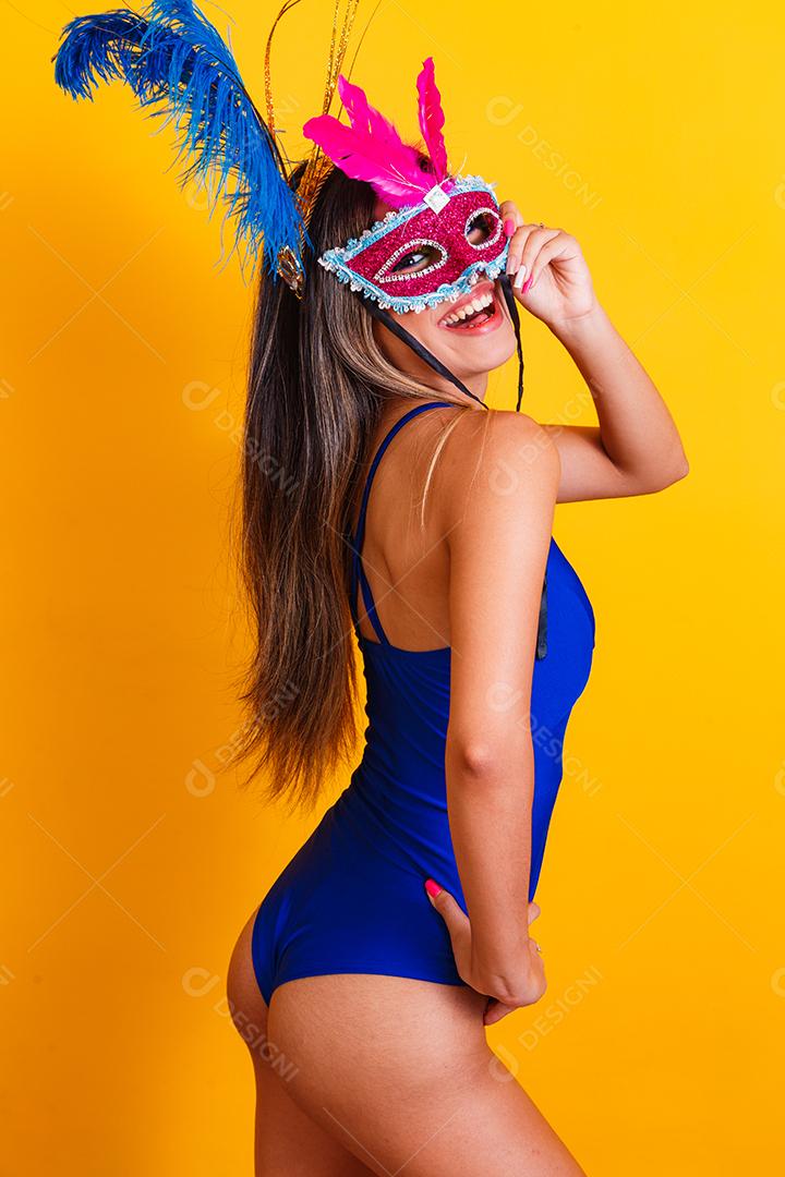 Mulher bonita vestida para a noite de carnaval. Mulher sorridente pronta para curtir o carnaval com máscara