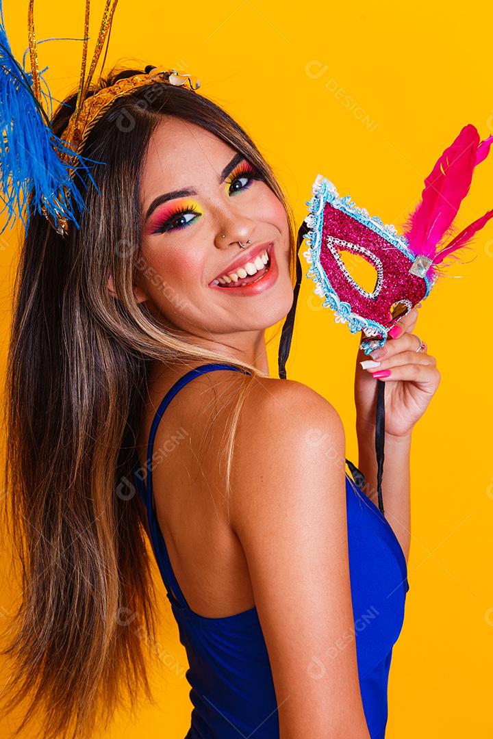 Mulher bonita vestida para a noite de carnaval. Mulher sorridente pronta para curtir o carnaval com máscara