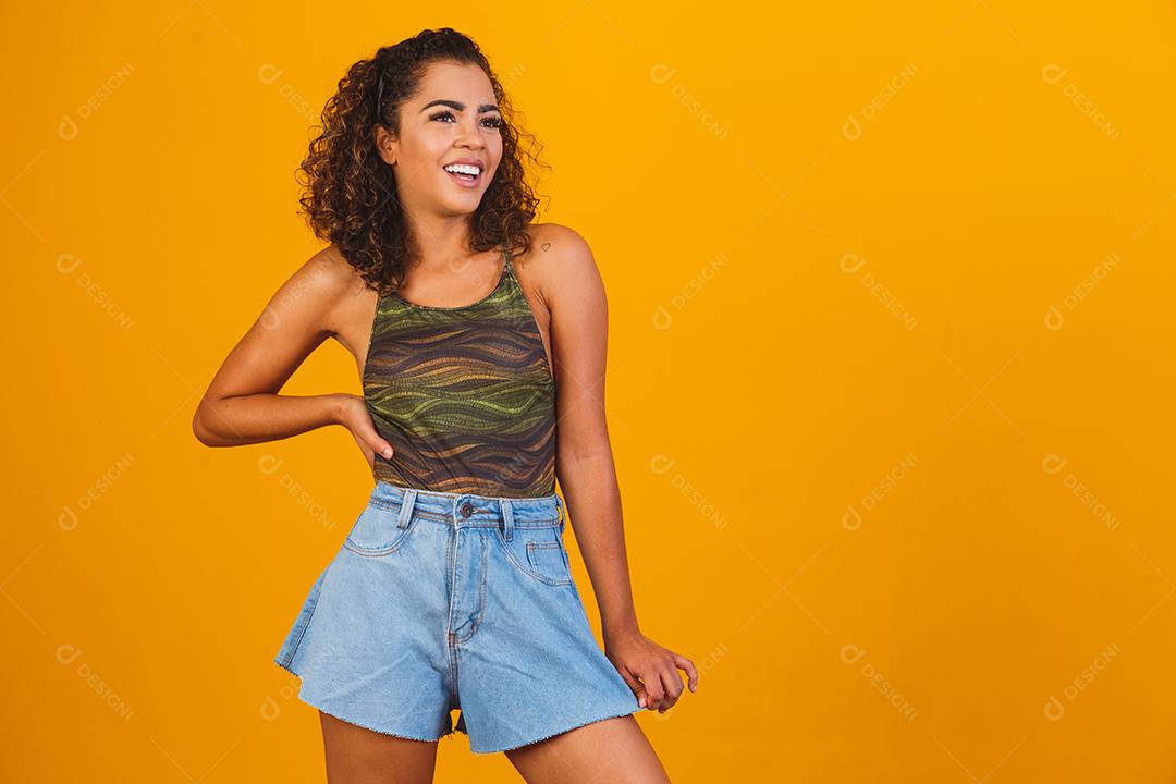 Linda garota afro sorrindo em fundo amarelo