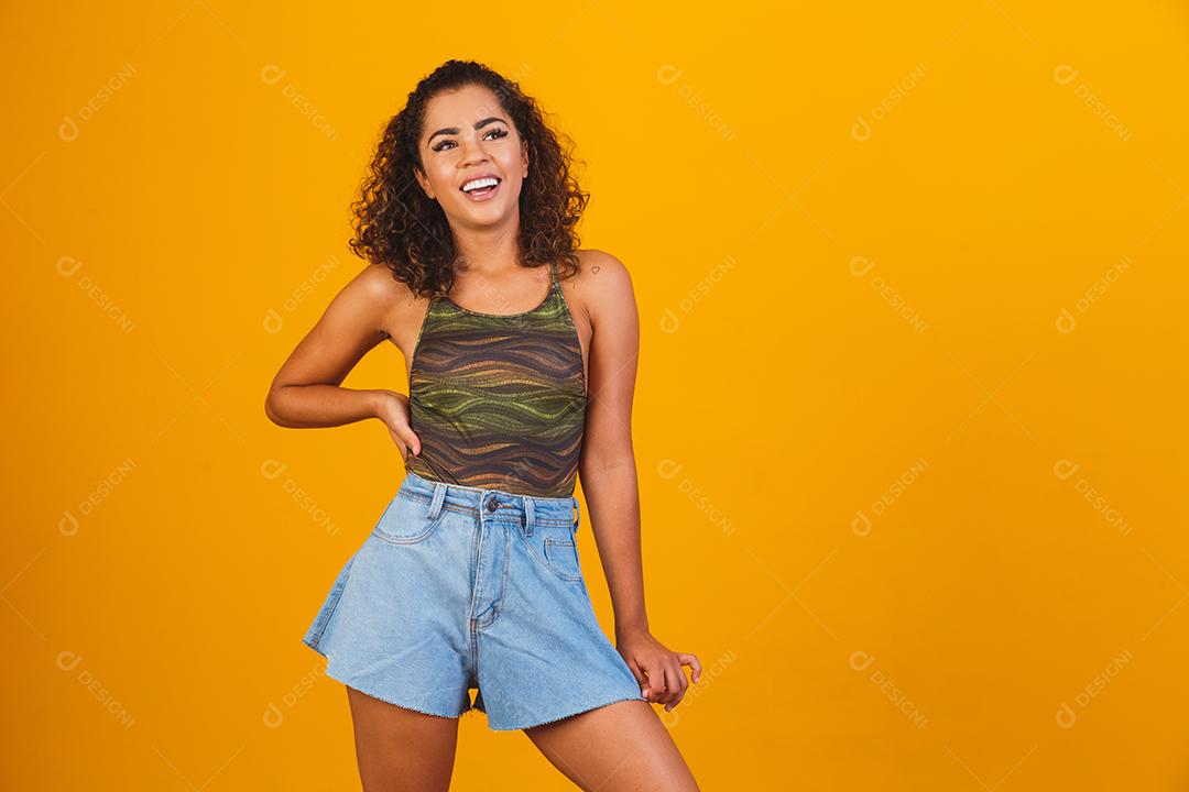 Linda garota afro sorrindo em fundo amarelo