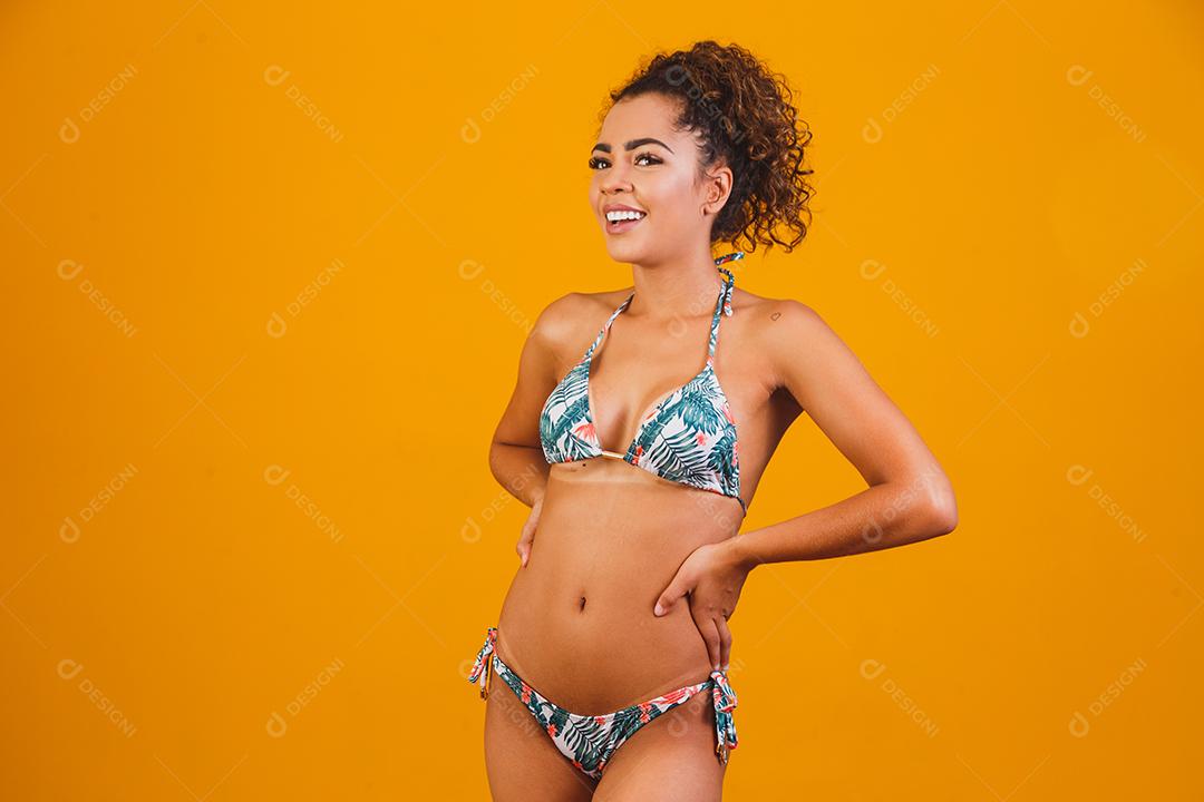 Linda mulher cabelo cacheado usando biquíni praia verão