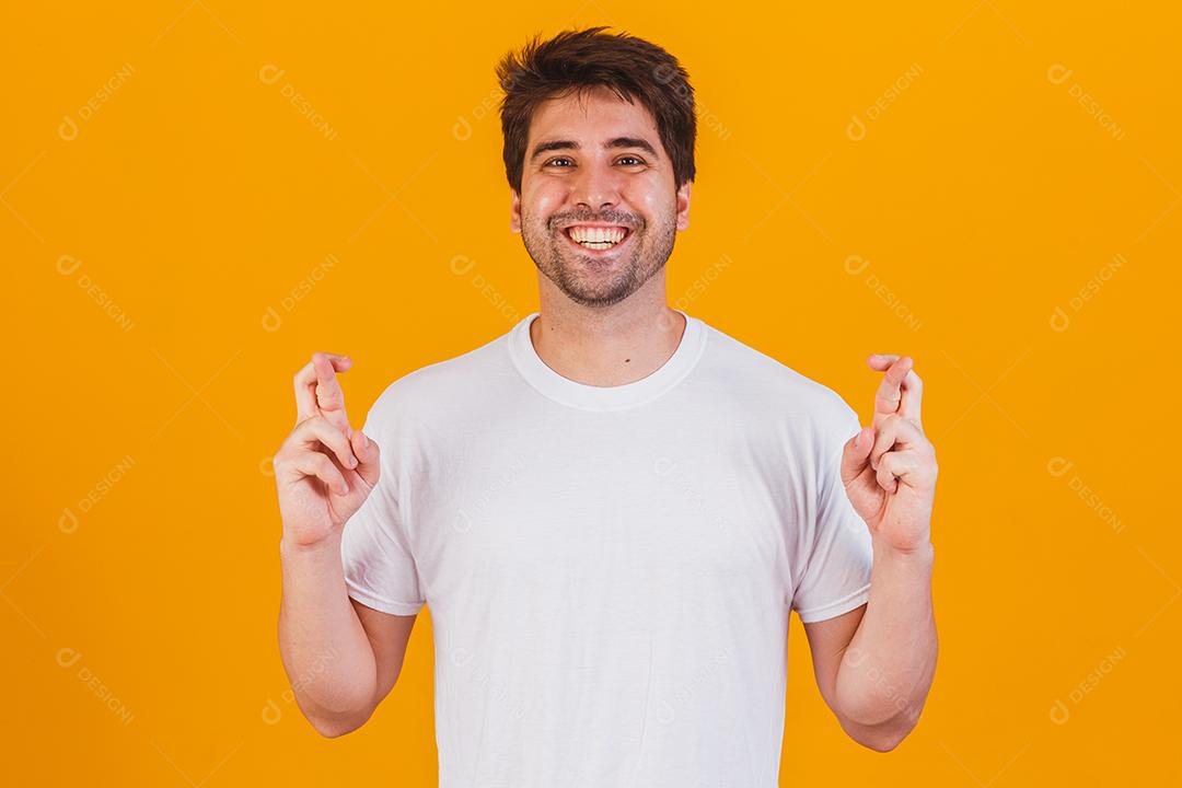 A portrait of a young man with fingers crossed