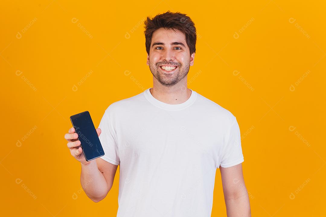 homem bonito com celular nas mãos apontando