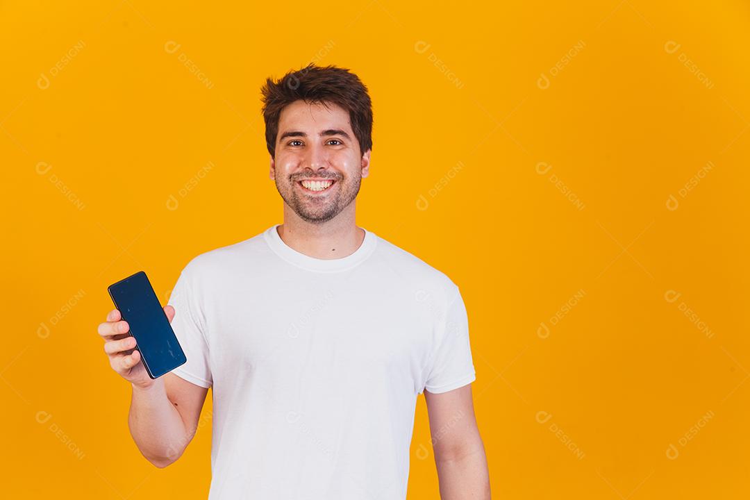 homem bonito com celular nas mãos apontando