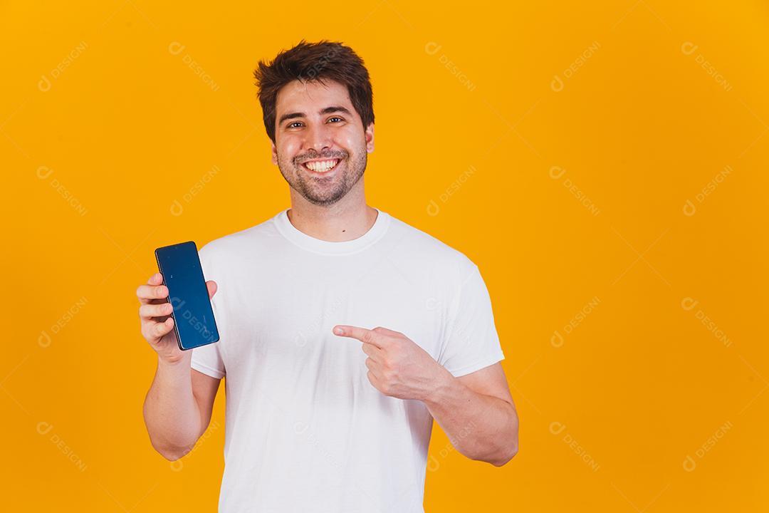 homem bonito com celular nas mãos apontando