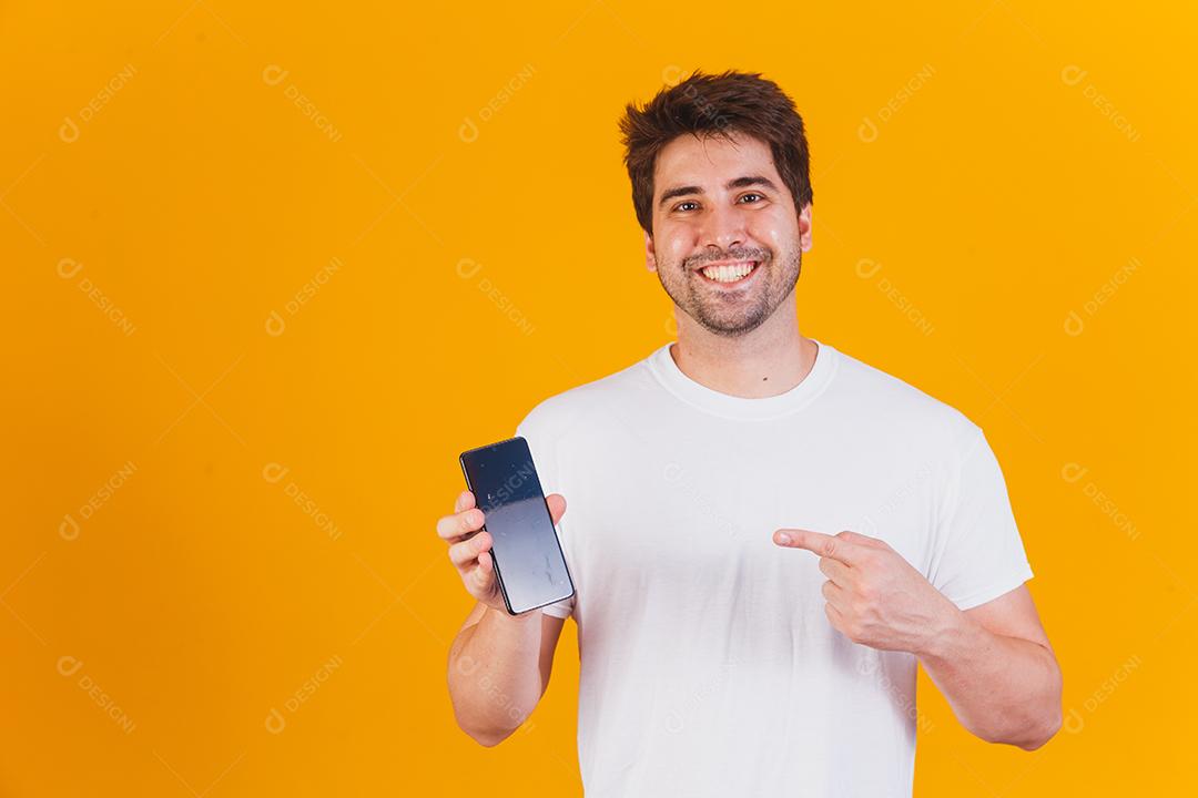 homem bonito com celular nas mãos apontando